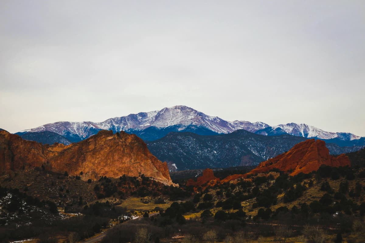 Red sandstone formations at Garden of the Gods with snow-capped Pikes Peak in the background