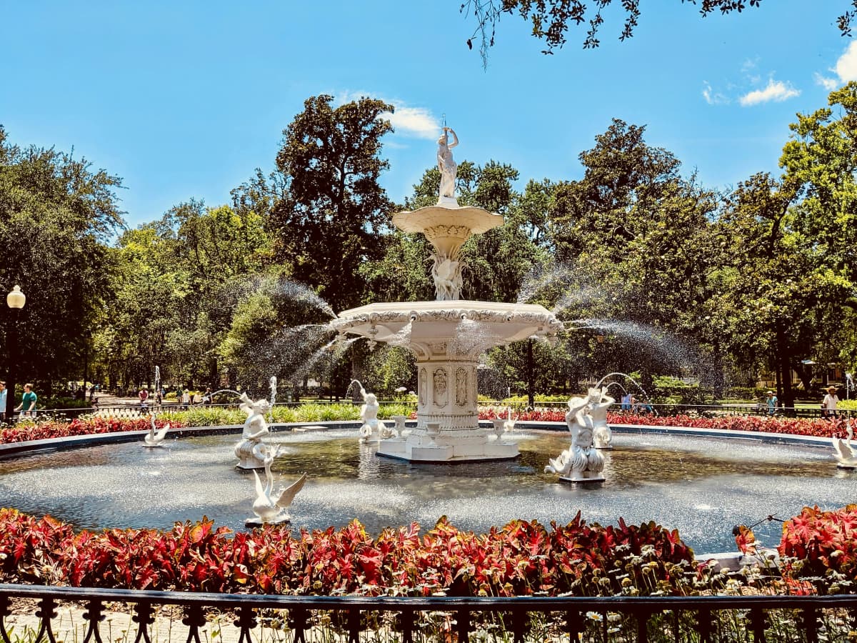 The white cast-iron fountain in Savannah's Forsyth Park framed by live oaks hung with Spanish moss
