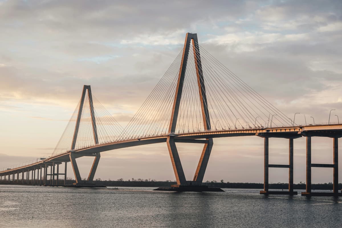 The Arthur Ravenel Jr. Bridge's white cable-stayed towers spanning the Cooper River in Charleston at sunset