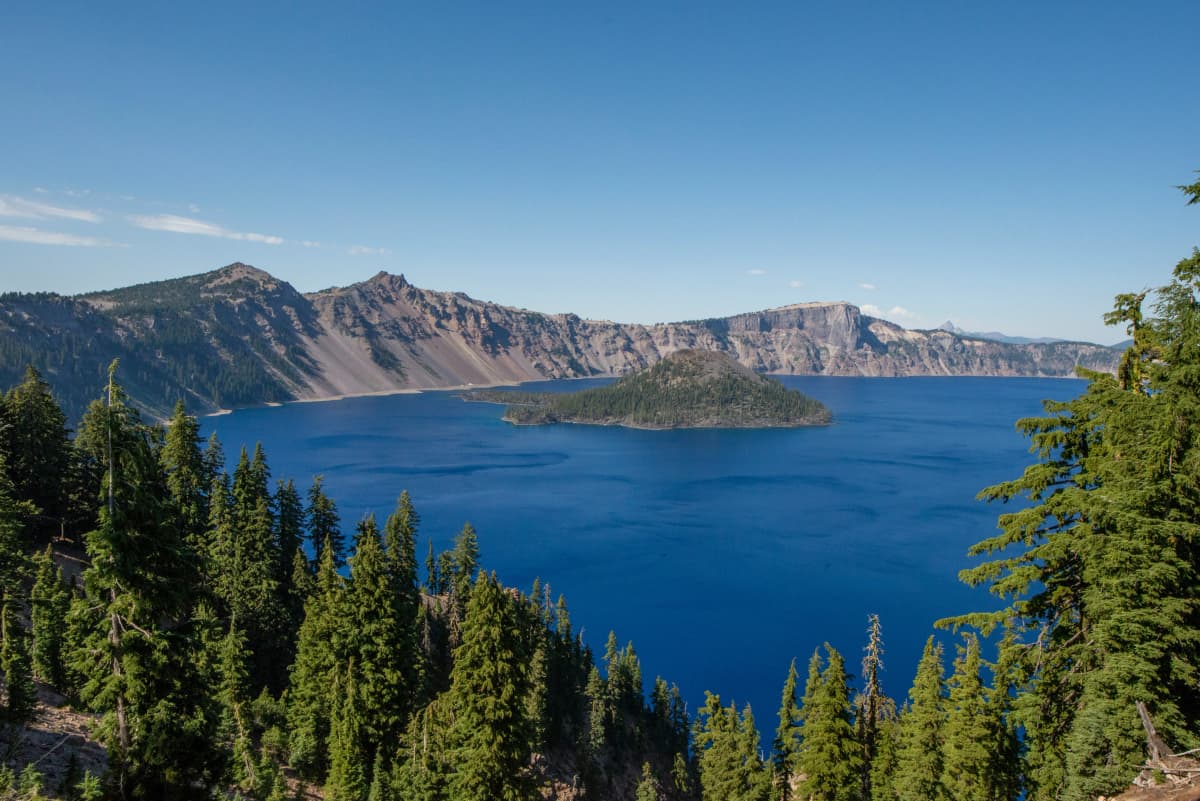 Deep blue Crater Lake with Wizard Island rising from the water beneath the caldera rim