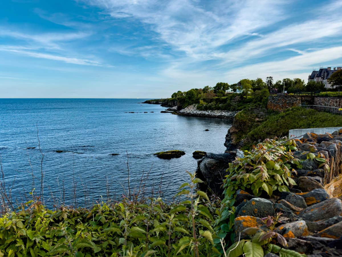 The Newport Cliff Walk path winding along rocky Atlantic shoreline below Gilded Age mansions