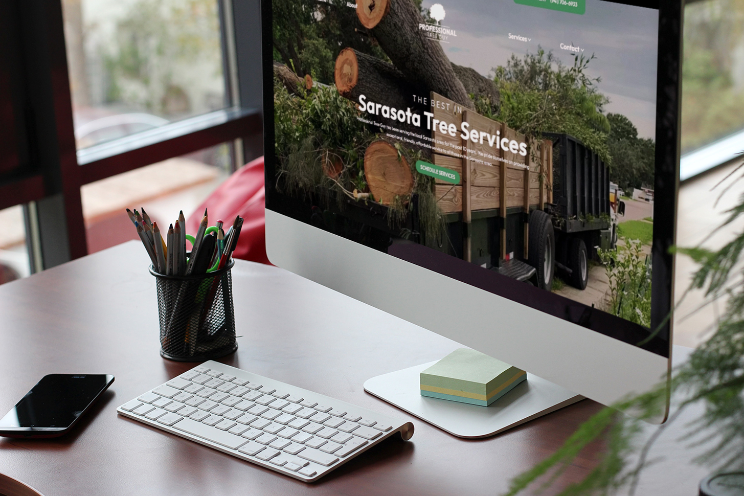 desktop computer on desk showing a tree service on screen